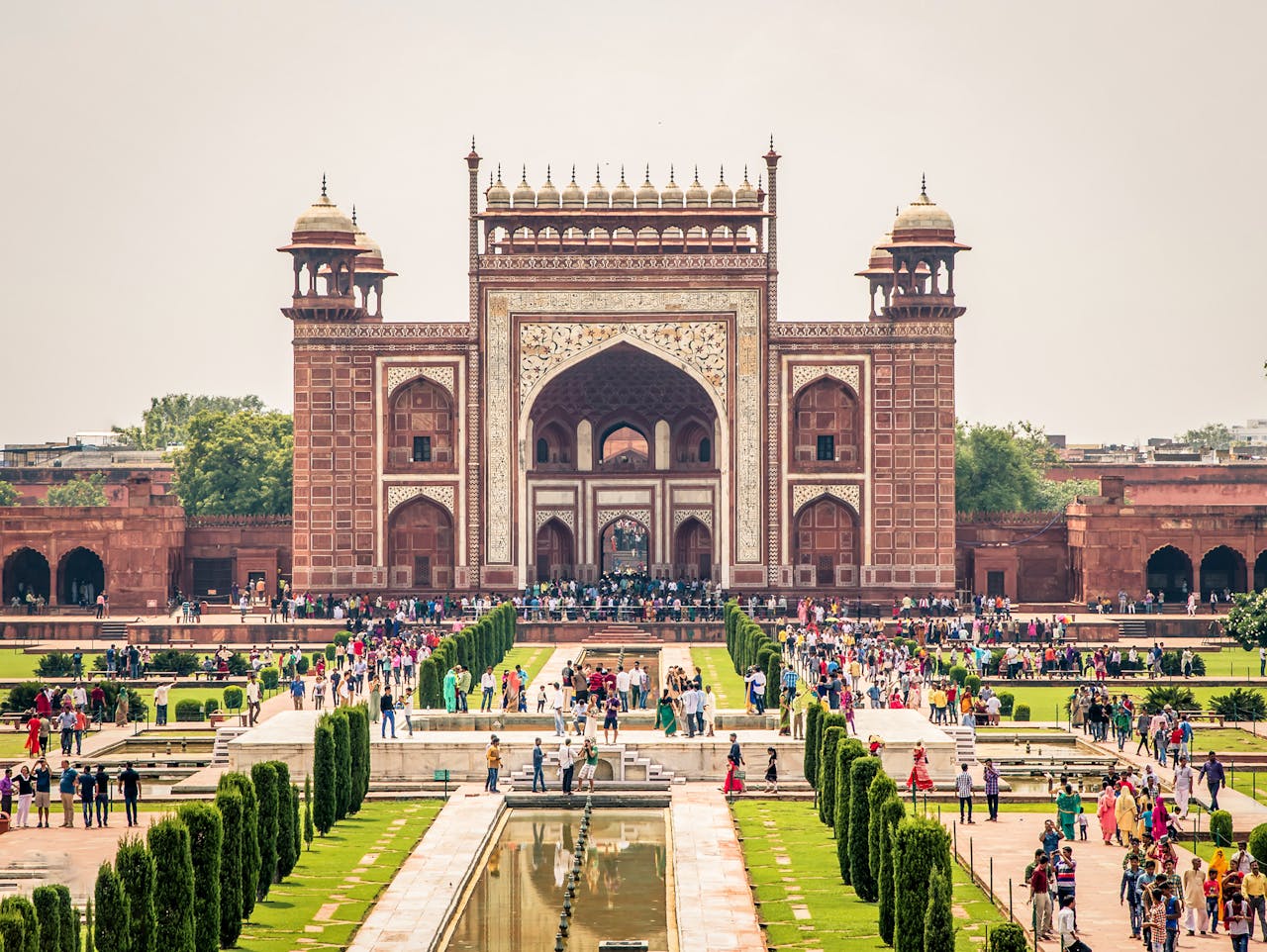 View of the grand entrance at a famous landmark in Agra, India, with many tourists visiting.